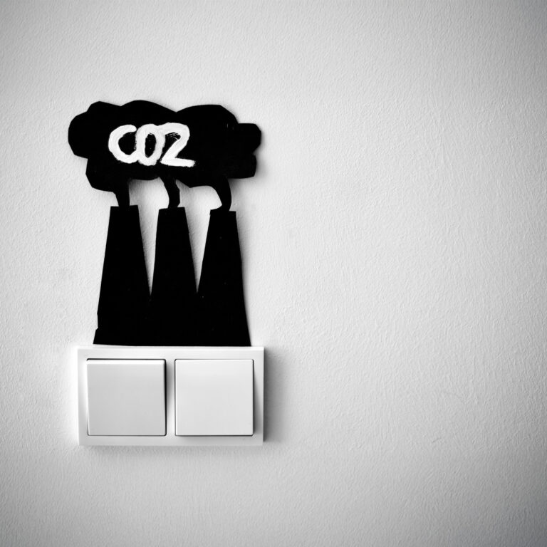 Illustration of CO₂ emissions symbolised by factory chimneys above a light switch, representing the link between energy use and carbon neutrality in buildings.