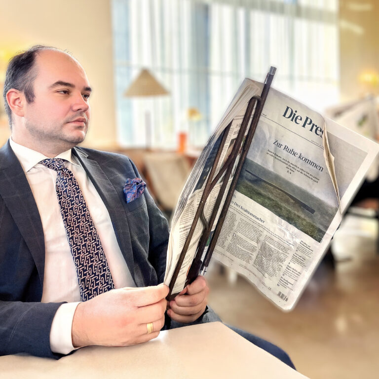 Robert Tomić, architect in Vienna, reading Die Presse while reflecting on housing decisions.