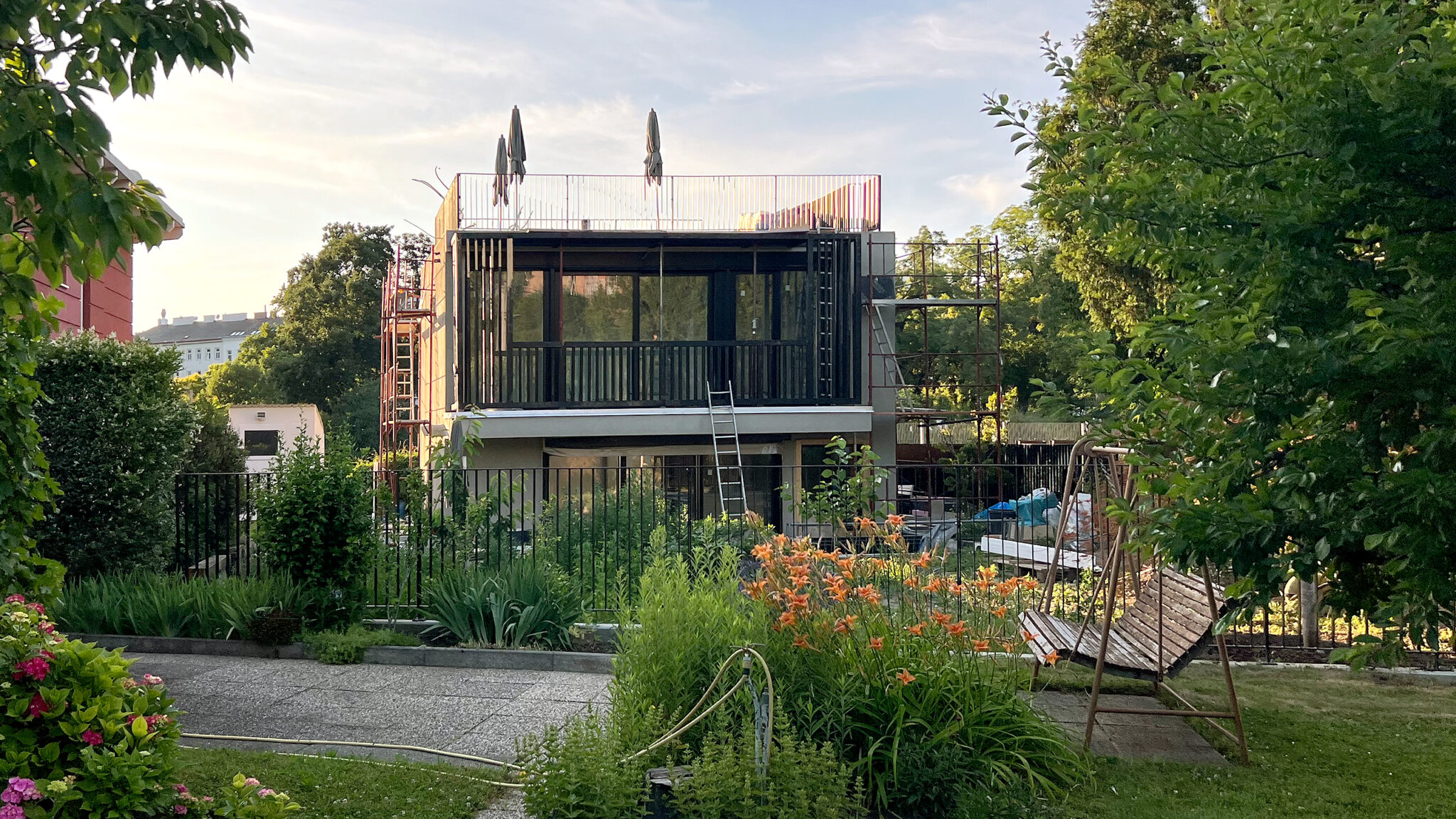 Kleingartenhaus in Vienna with modern façade, roof garden, and flowering front garden.