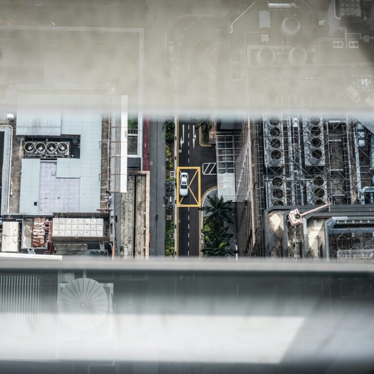 Aerial view of urban rooftops with ventilation units and solar installations — illustrating the role of existing buildings and infrastructure in achieving carbon neutrality through renovation and energy efficiency.